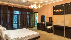 Una habitación de hotel con cama, televisión, cómoda y armario.