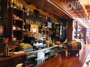 A bar with shelves of bottles, a coffee machine, and a barrel. - The House of Telegraphs (Vallehermoso)