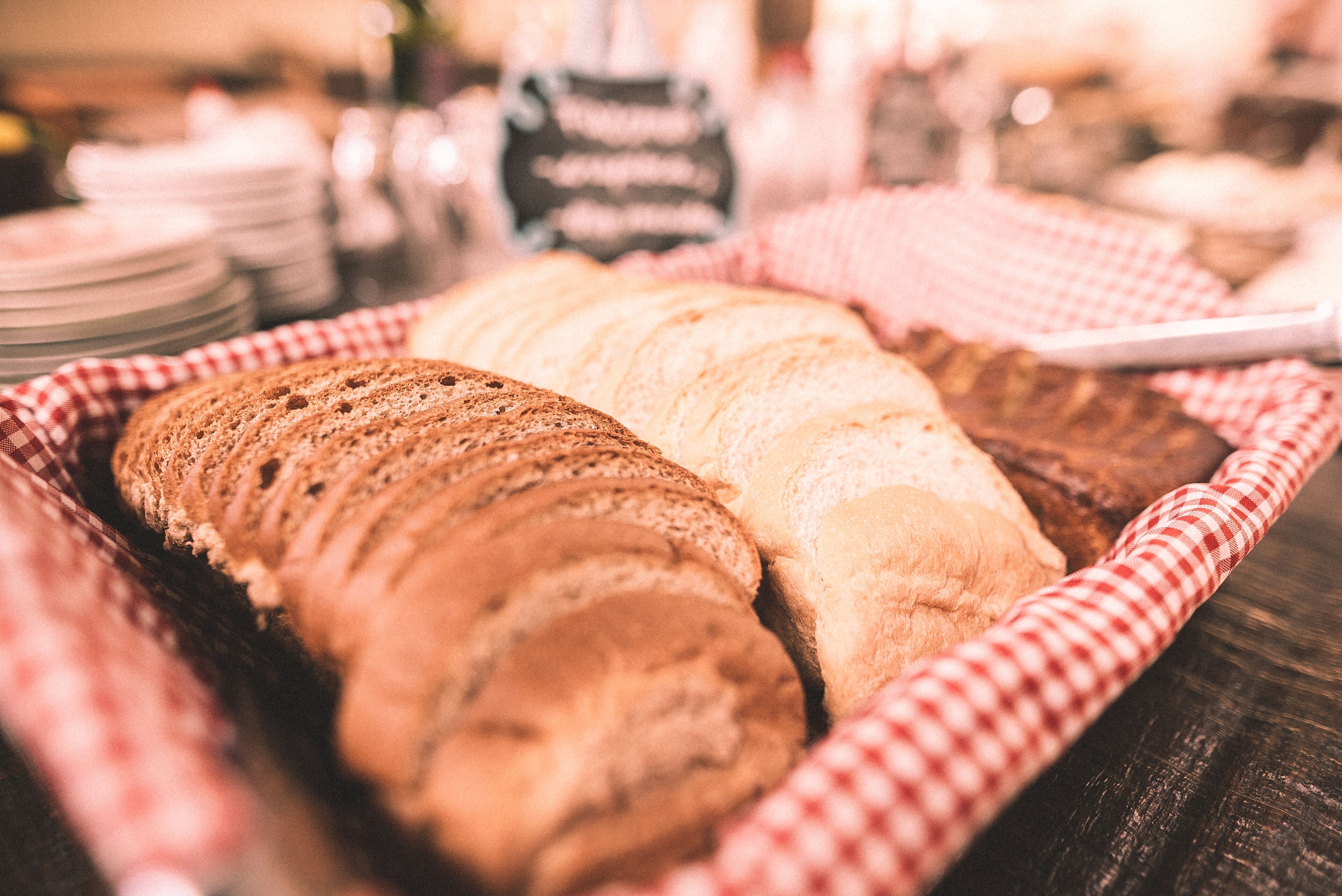 Ein Korb mit Scheibchenbrot auf karierter Tischdecke.