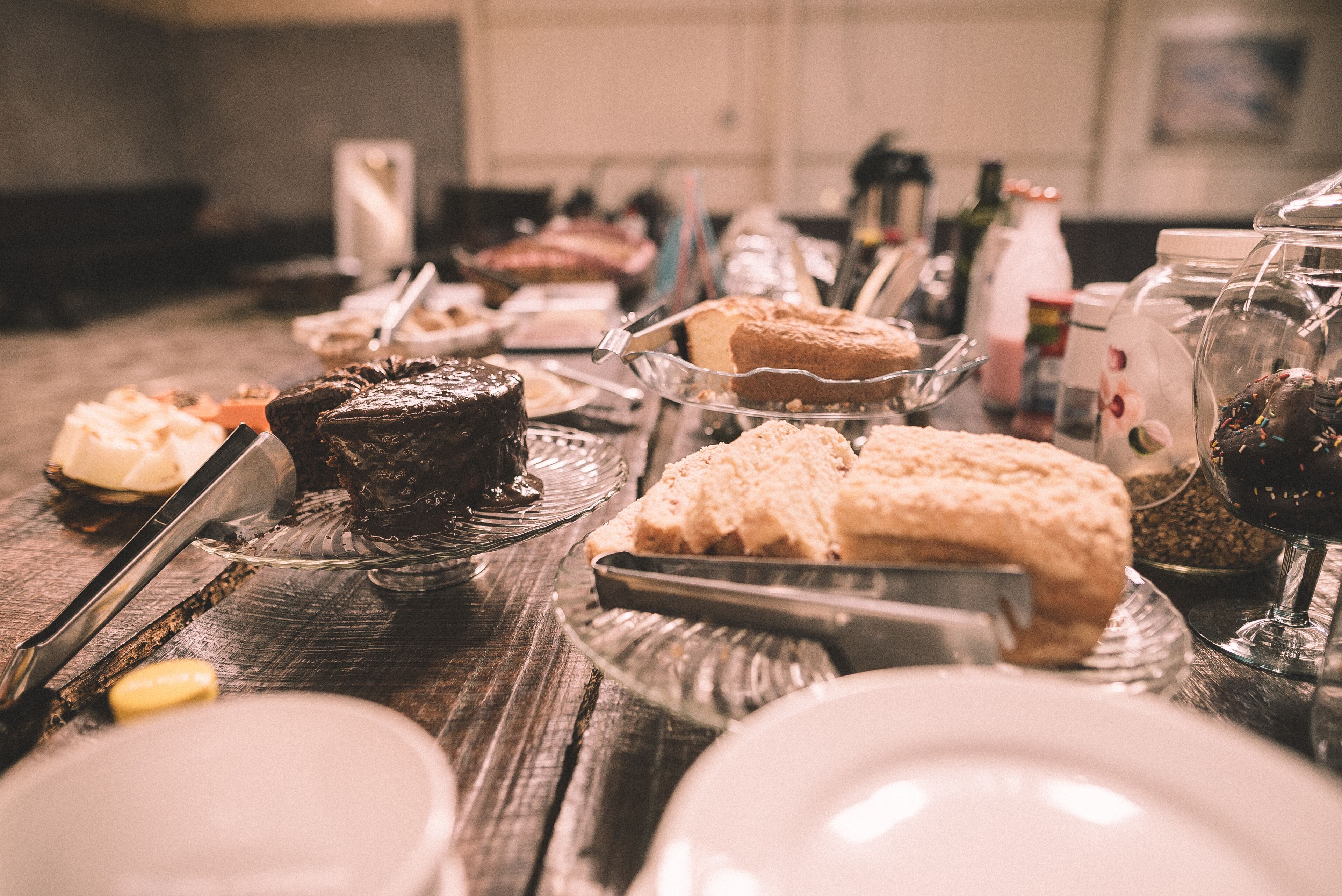 A table with various desserts and a wine glass.