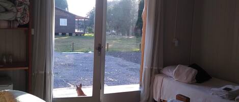 Una habitación de hotel con cama, una mesita y vistas al exterior.