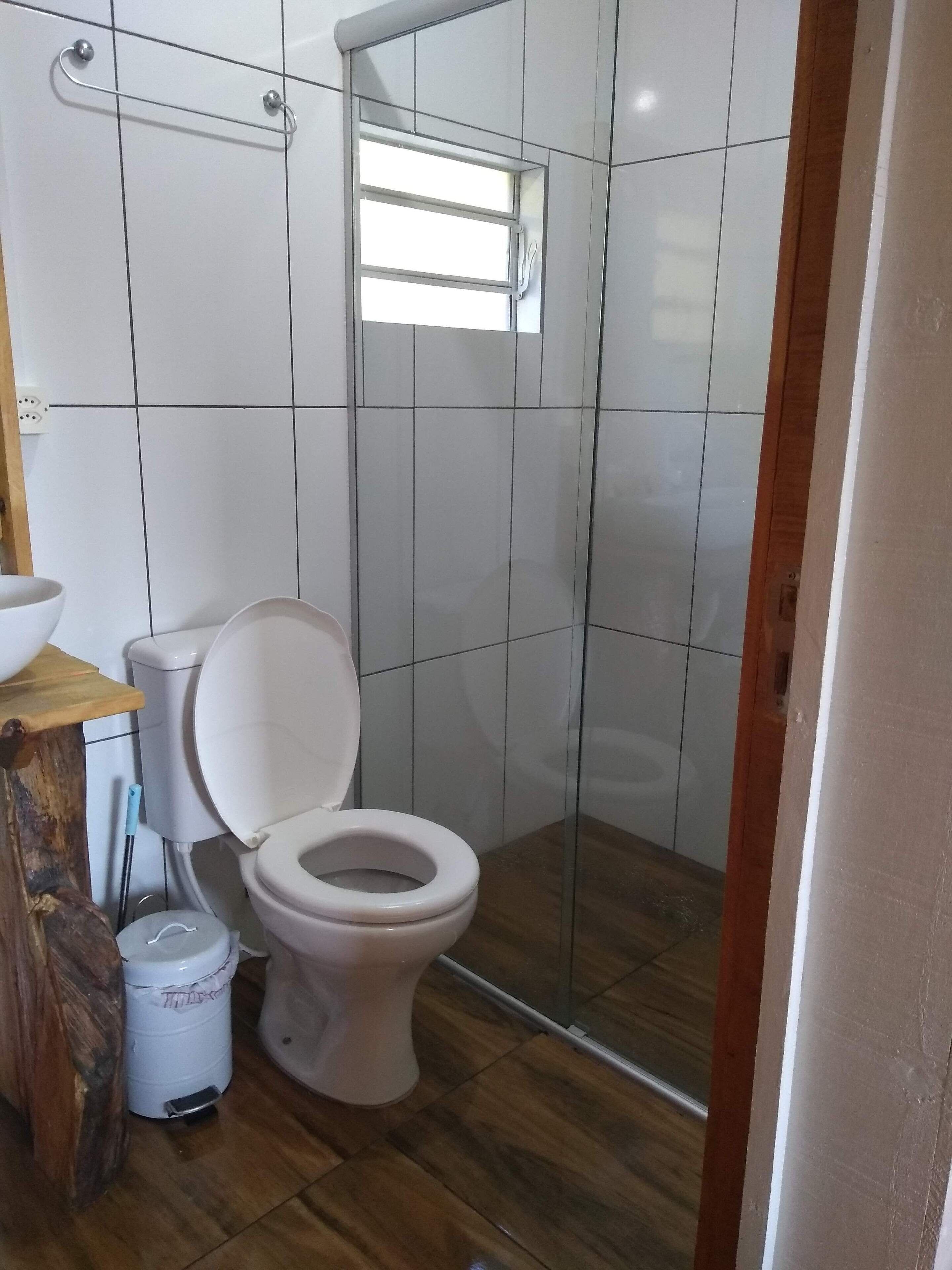 A bathroom with a toilet, a sink, and a shower area.