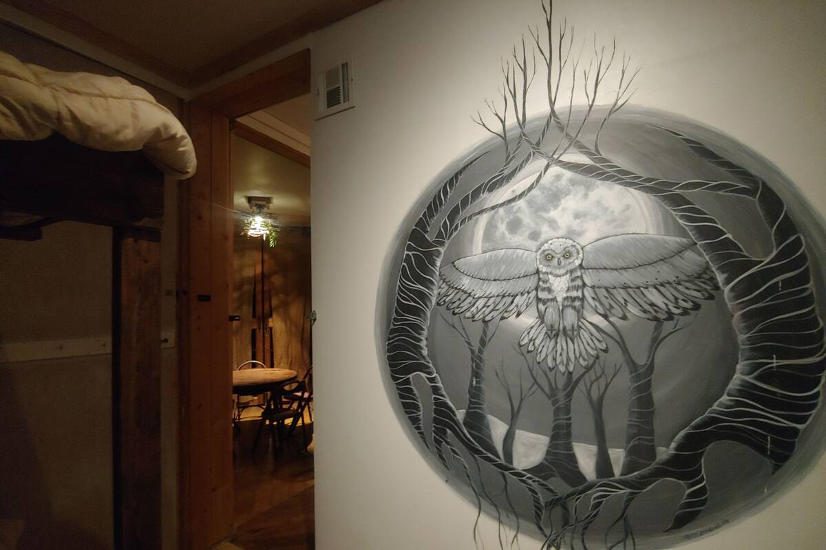 A circular artwork of an owl with branches and a moon in the background.