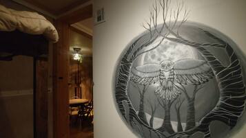 A circular artwork of an owl with branches and a moon in the background.