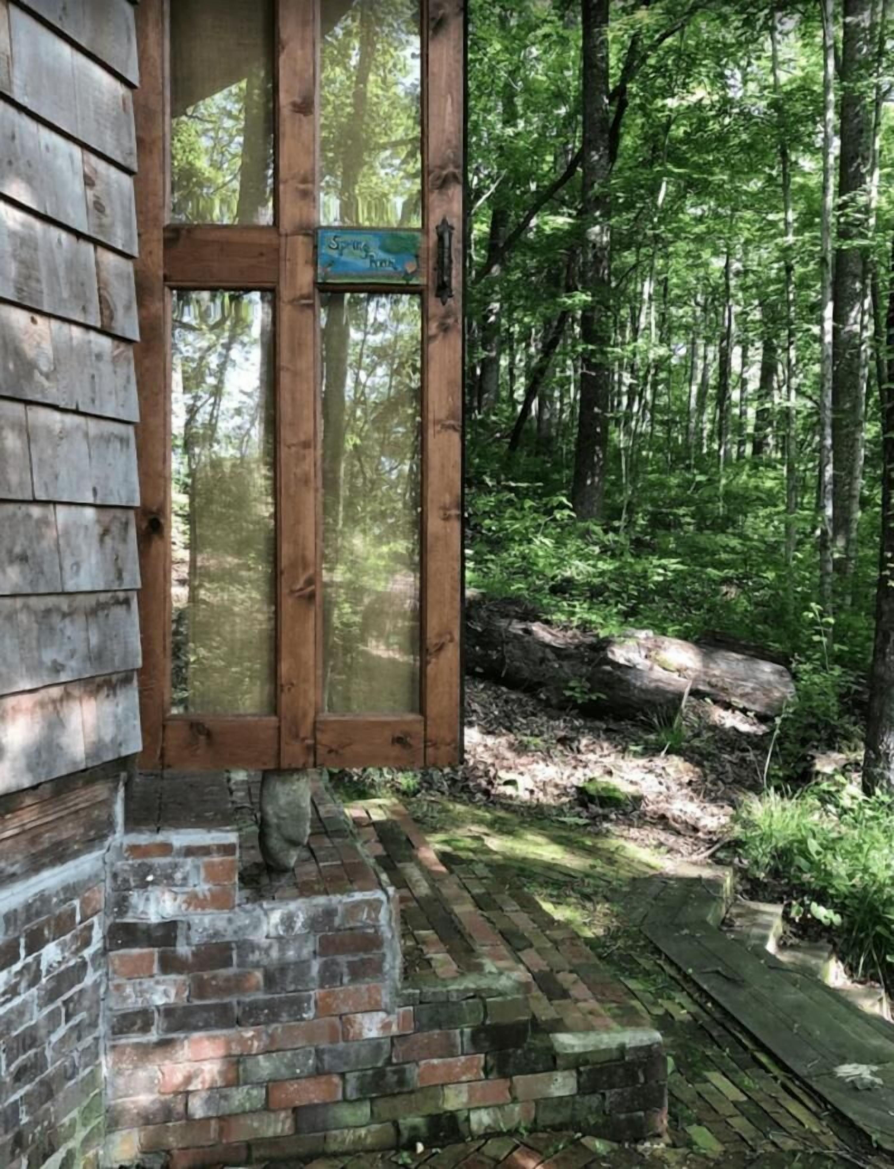 Une cabane en bois rustique, avec une entrée en briques et une enseigne sur laquelle on peut lire : « Spice the River ».