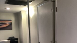 A modern office space with a glass partition, a desk with a chair, and a printer. - Beautiful Condo located at Makaha Valley Towers (Waianae)