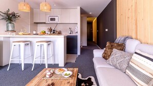 Eine moderne Küche mit weißen Schränken, einer Mikrowelle und zwei hängenden Korbstühlen.