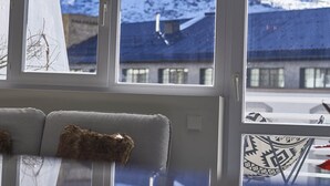 Ein Zimmer mit großem Fenster und Blick auf schneebedeckte Berge.