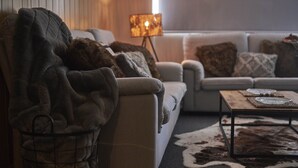 Ein gemütliches Wohnzimmer mit einer Couch, einem Couchtisch und einer Lampe.