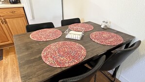 A dining table with four woven placemats, a metal tray, and salt and pepper shakers. - Bungalow on a private 70 acre ranch (Austin)