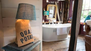 Un baño con una bañera, una toalla y una bolsa etiquetada "QUAL POTAT".