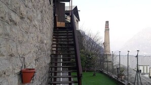Un edificio de piedra con una escalera de madera que conduce a un espacio cubierto.