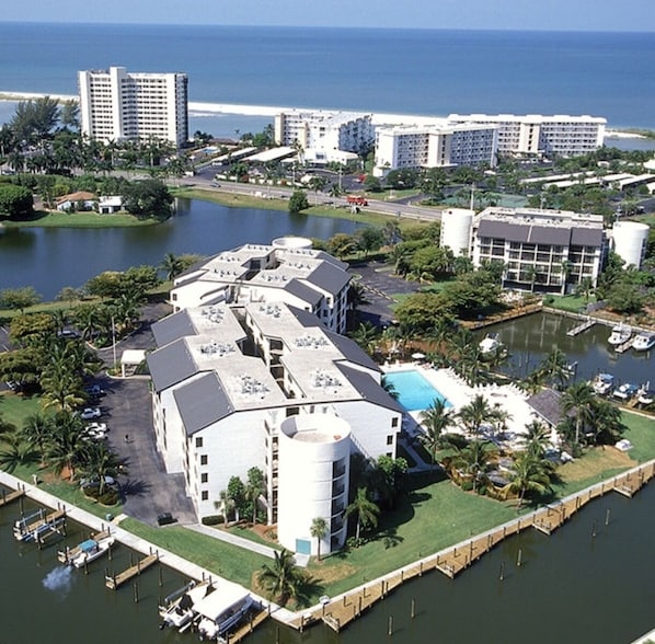 A coastal hotel with multiple buildings, a marina, and a view of the ocean. - Santa Maria awaits you! Large heated pool! (Fort Myers Beach)