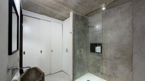 A modern bathroom with a stone sink, a glass shower enclosure, and a white tiled floor. - Zona Romantica Beautiful Modern Studio (Emiliano Zapata)