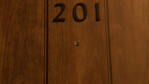 Une porte en bois portant le numéro 201.