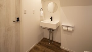Une salle de bain avec un lavabo blanc, un miroir et un porte-serviettes.