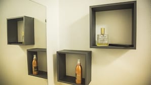 Un baño con tres repisas grises oscuras, cada una con una botella de producto para el cabello.