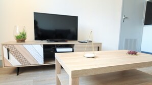 Una sala de estar moderna con un mueble de televisión de madera, un televisor de pantalla plana y una mesa de centro minimalista.