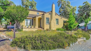 A single-story house with a yellow exterior, a chimney, and a front porch. - 1927 - Murphys Vacation Rentals (Murphys)