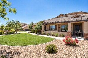A residential building with a well-maintained lawn, a patio area, and a variety of shrubs and plants. - Spacious backyard & 2 pools/spas, fishing pond (Washington)