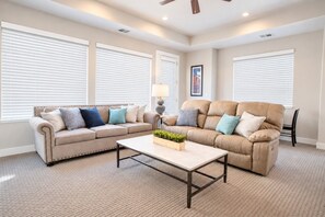 A living room with two sofas, a coffee table, and a lamp. - Spacious backyard & 2 pools/spas, fishing pond (Washington)