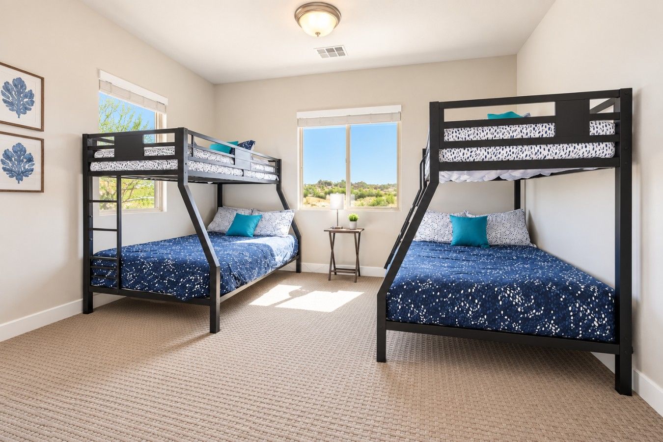 A room with two bunk beds, a small table, and a window with a view.