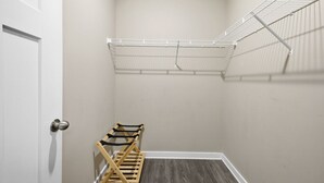 A small, enclosed room with a white door, a wooden bench, and a wire shelf. - 1 mile Walk to Broadway* #203 (Nashville)