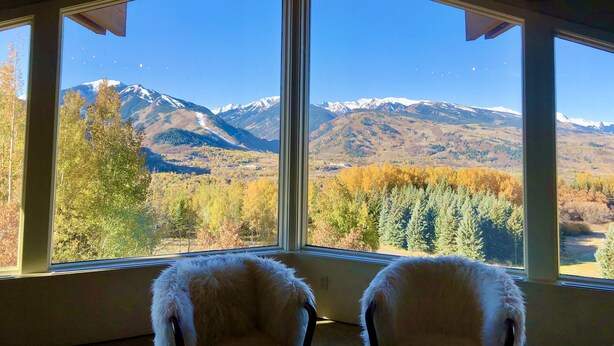 Ein Zimmer mit großen Fenstern und Blick auf die Berge.