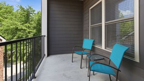 A balcony with two chairs, a metal railing, and a window with blinds. - 1 mile walk to Broadway! 2 Bd*2 Bth  #303 (Nashville)