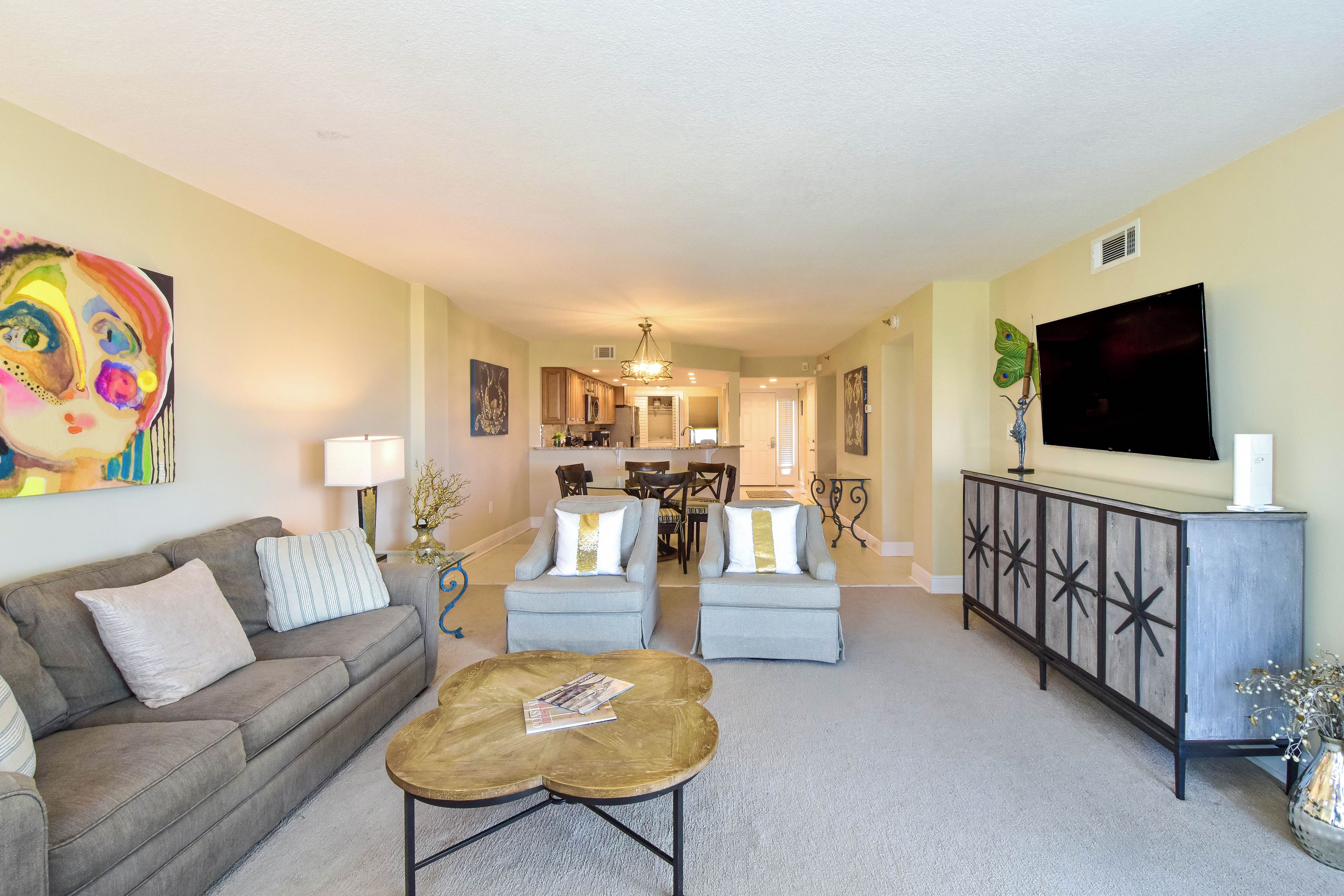 A living room with a sofa, coffee table, and a TV on a cabinet.
