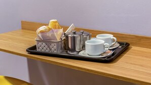 A breakfast tray with croissants, a coffee pot, and two white cups on a wooden table. - Lord Palace Hotel (Varzea Grande)
