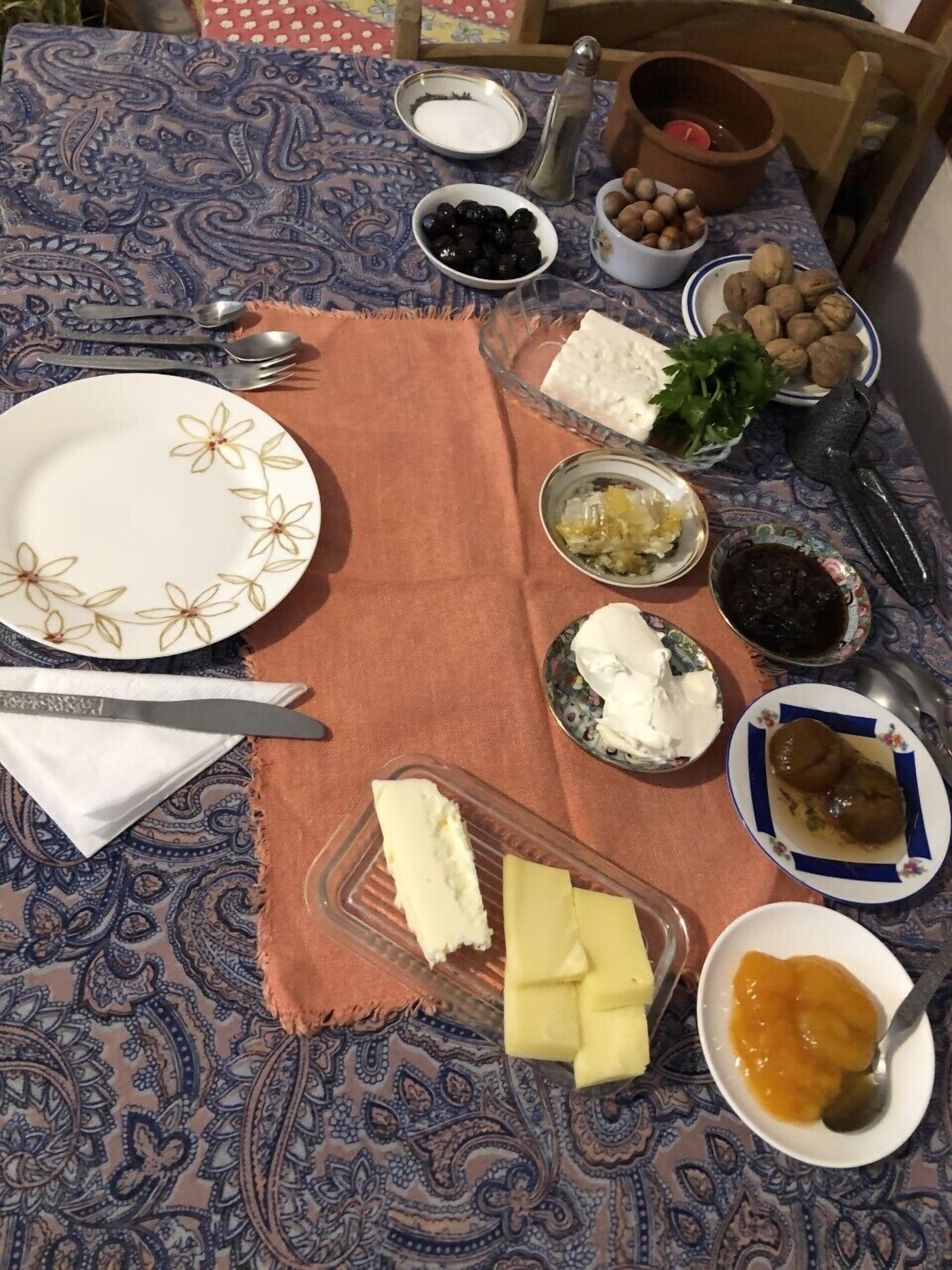 A table set with various food items including cheese, olives, and nuts.