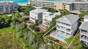 Un resort con diversi edifici, una piscina e vista sull'oceano.