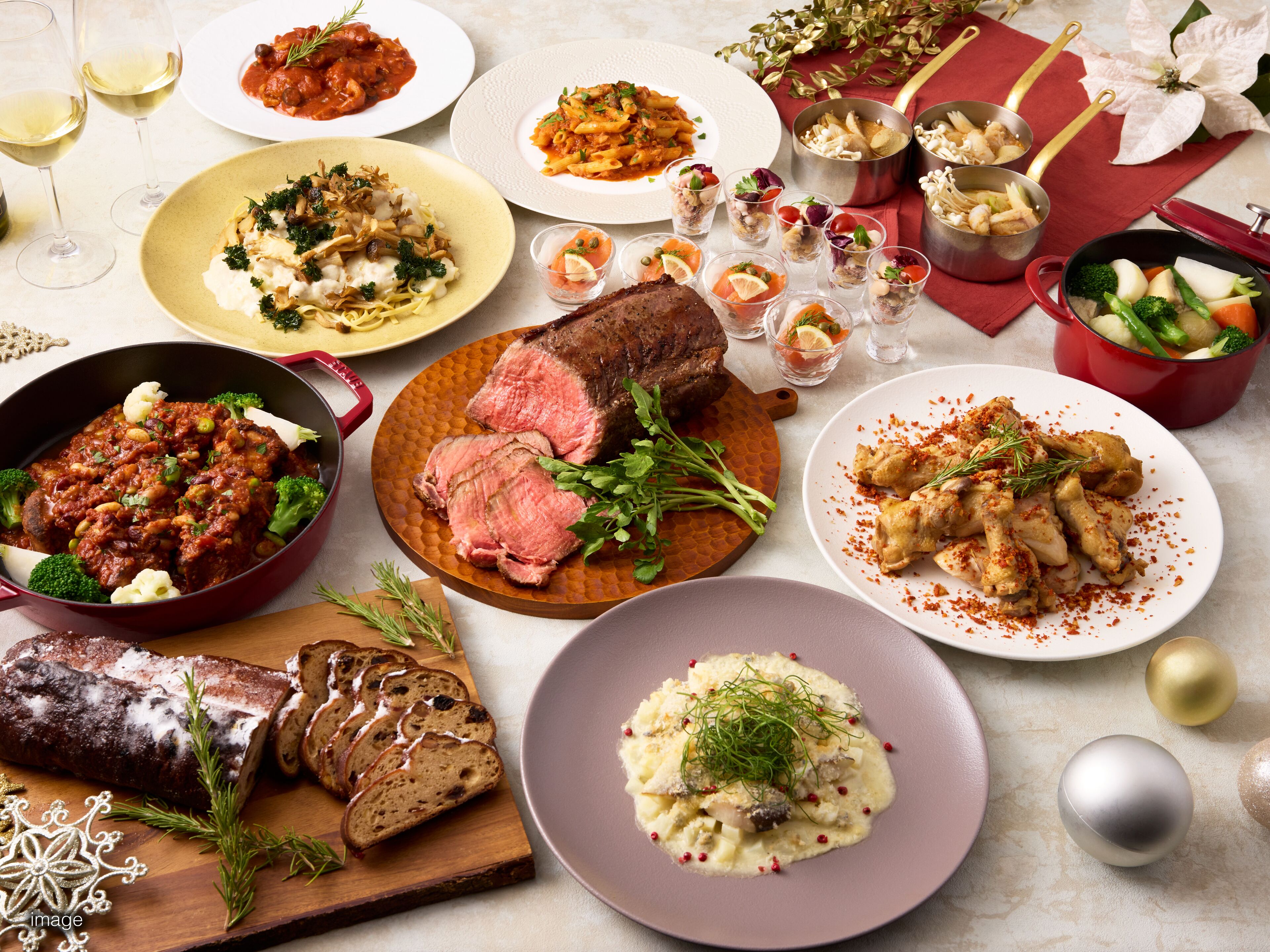 A variety of dishes including steak, pasta, and bread, suggesting a meal setting.