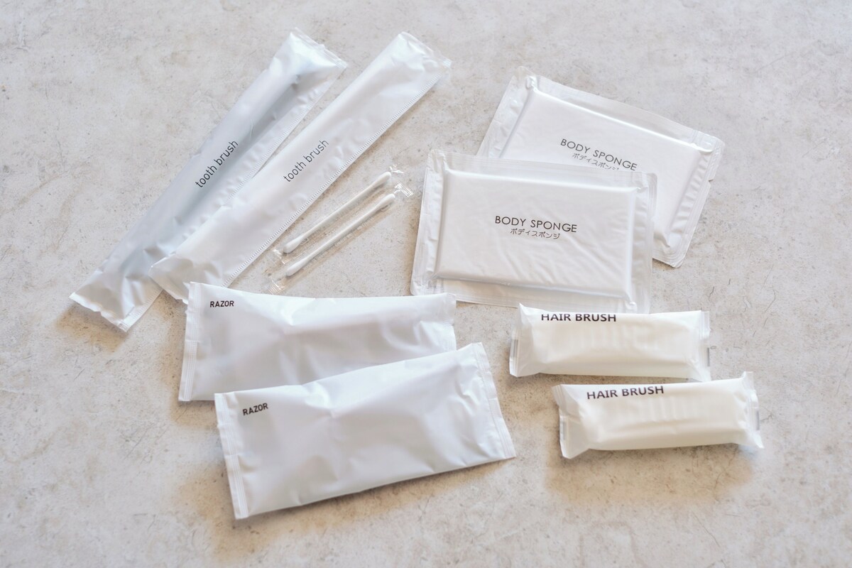 Una colección de artículos de tocador, incluyendo una esponja de baño, navaja y cepillo para el cabello.