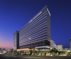 A modern hotel with a prominent horizontal facade and a rooftop terrace.