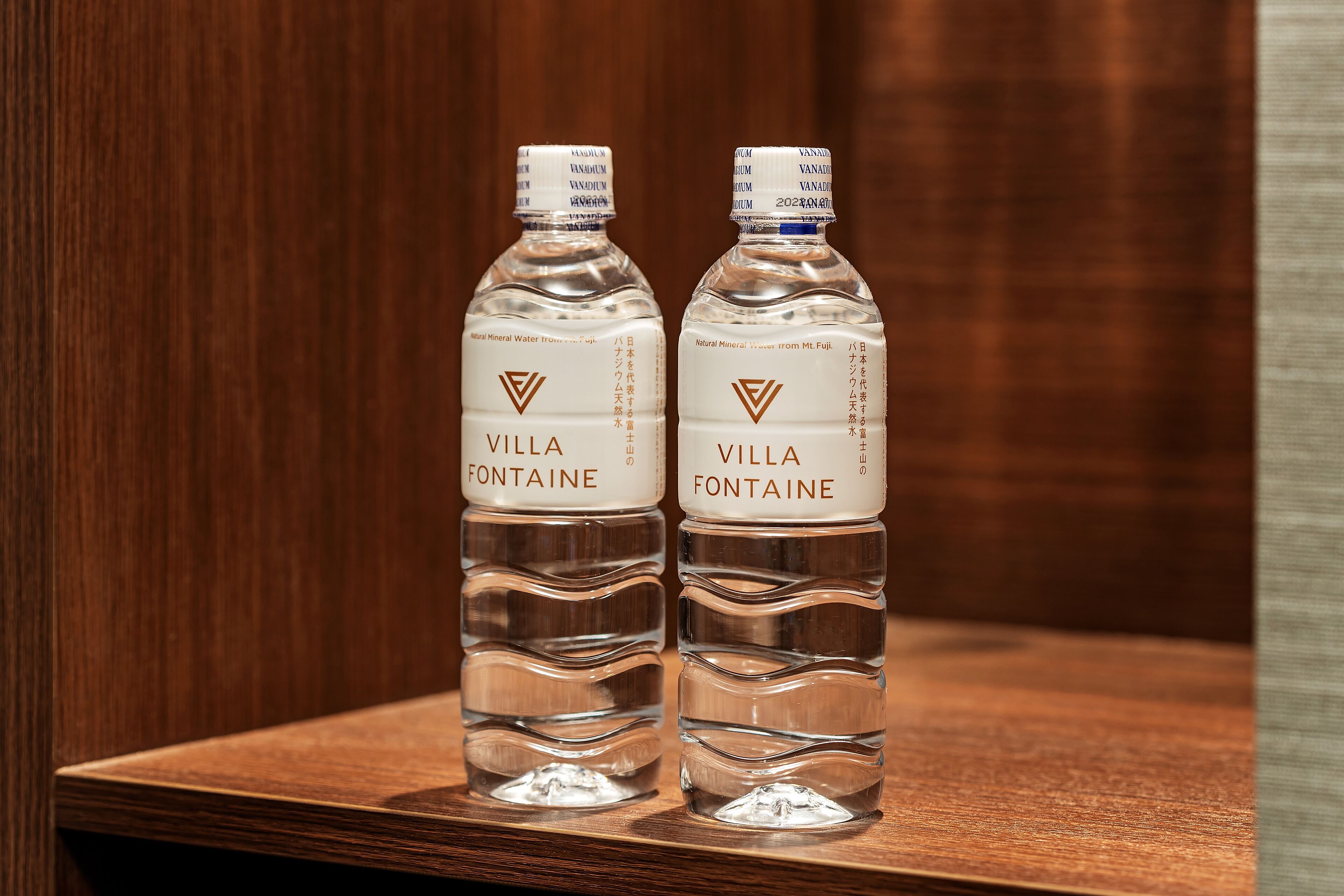 Dos botellas de agua Villa Fontaine sobre una superficie de madera.