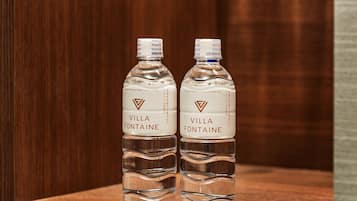 Two bottles of Villa Fontaine water on a wooden surface.