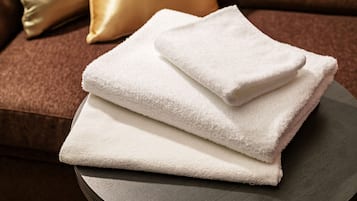 A stack of white towels on a round table.