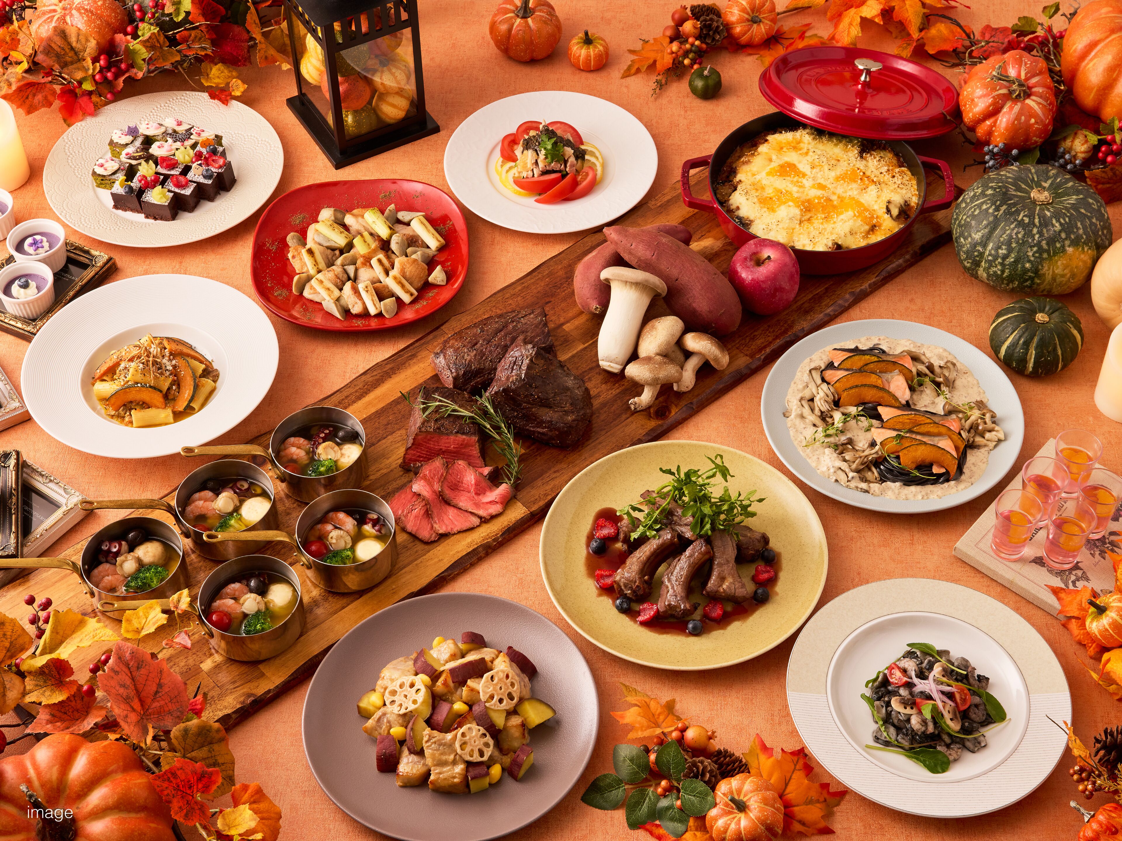 Une variété de plats et de décorations sur le thème de l’automne sont disposés sur une table.
