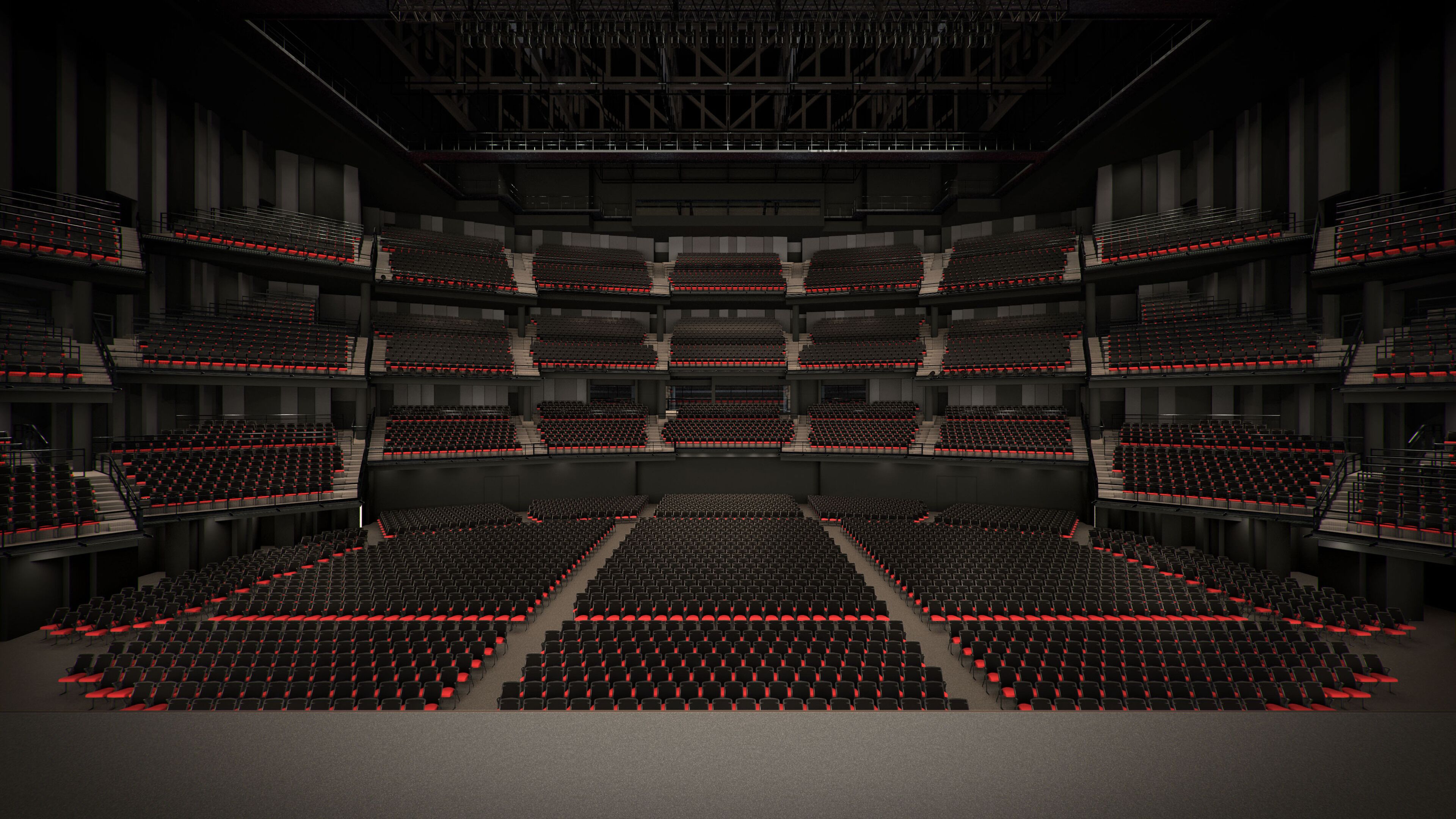 A large, multi-level auditorium with tiered seating and red accents.