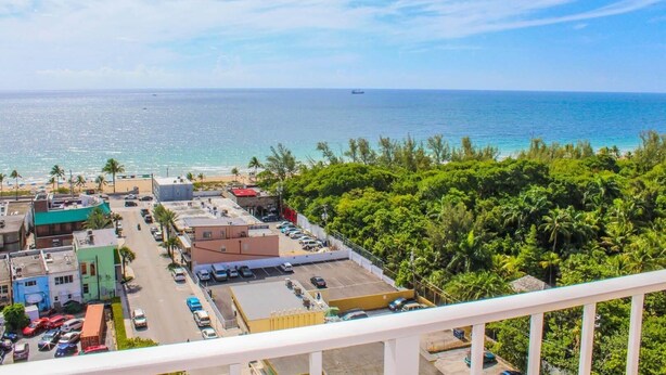 A coastal town with a view of the ocean, a parking lot, and buildings with a mix of commercial and residential structures.