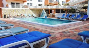 Relax by the rectangular pool surrounded by comfortable lounge chairs and umbrellas.