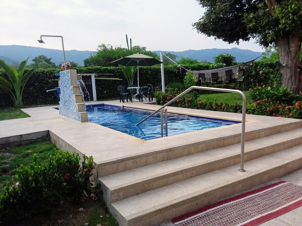 Outdoor pool, open 10:00 AM to 10:00 PM, pool umbrellas