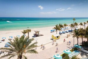 A beach with palm trees, umbrellas, and a lifeguard tower. - ★ Rocking 2 BR Apt ★ Near Hard Rock Casino & Beach (Hollywood)