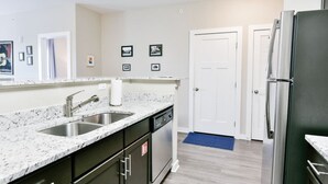 A modern kitchen with granite countertops, stainless steel appliances, and a built-in dishwasher.