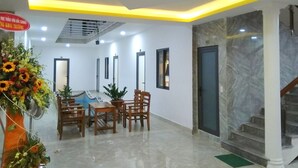 A hotel lobby with a reception desk, seating area, and a staircase. - Hung Yen Hotel (Phu Quoc)