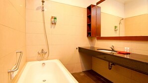 A bathroom with a bathtub, a sink, and a shower. - Kuta Paradise 777 (Legian)