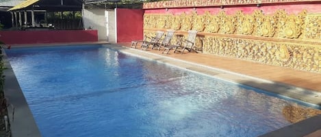 Una piscina al aire libre, sombrillas