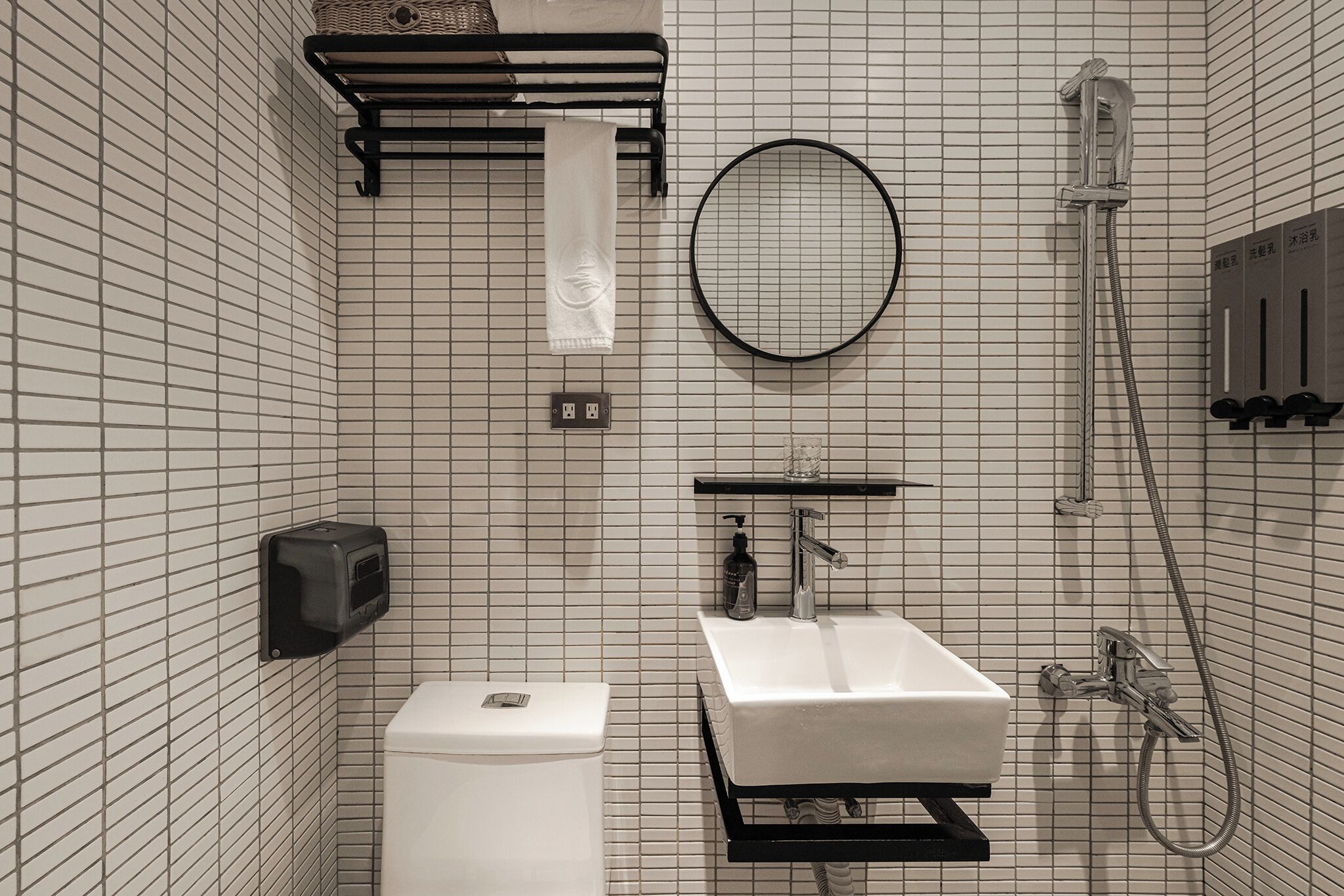 A bathroom with a toilet, sink, towel rack, mirror, and shower.